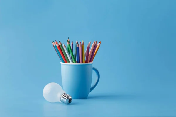 创新思想理念与杯子的铅笔和灯泡 — 图库照片