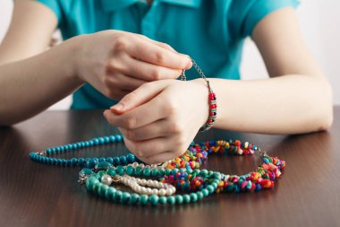 Kız elini ve bir demet takı bilezik koyar