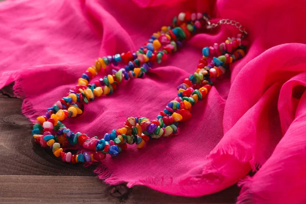 Perhiasan diatur dalam gaya oriental kalung manik-manik pada selendang sutra merah muda — Stok Foto