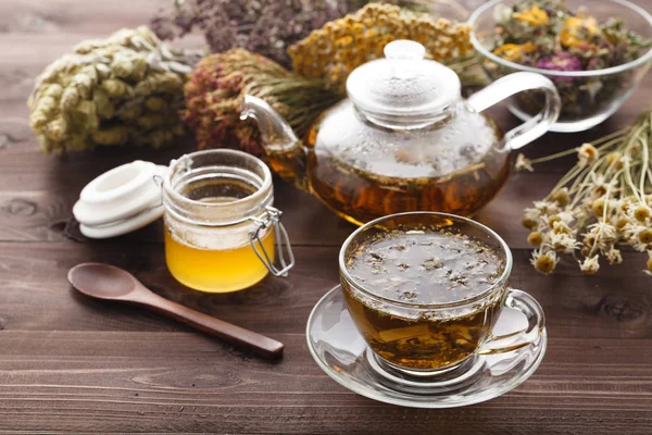 Лікувальний чай в скляній чашці з сушеною травою в мисці — стокове фото
