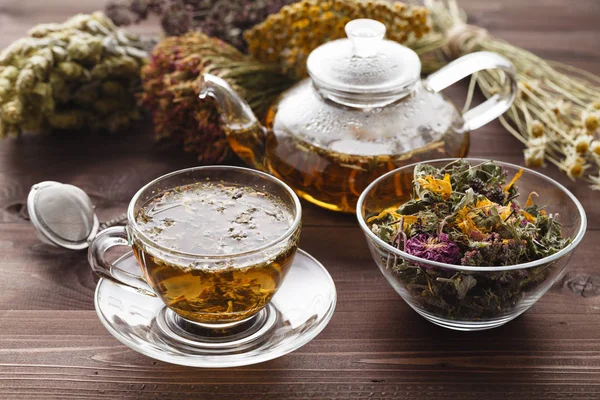 Tè medicinale in tazza di vetro con erba secca in ciotola — Foto Stock