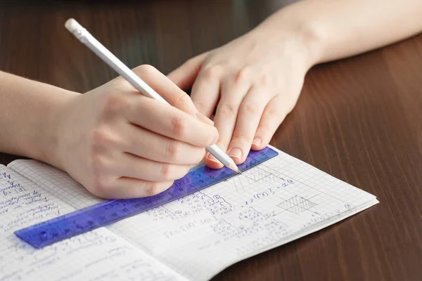 Girl writes in a notebook mathematical formulas — Stock Photo, Image
