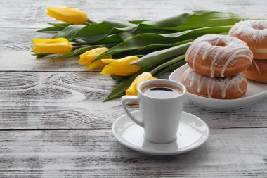 Masaya çörek ve sarı çiçek ile Kahvaltı