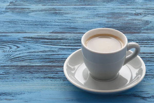 Чашка кави на бірюзовому дерев'яному столі — стокове фото