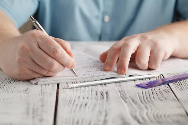 Κοντινό πλάνο αρσενικού χέρι γραπτώς σε χαρτί, γράφοντας ακατάστατο μαθηματικά, φοιτη — Φωτογραφία Αρχείου
