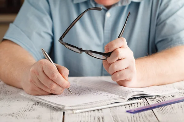 Fechar a mão do macho escrevendo no papel, escrevendo matemática confusa, tutor — Fotografia de Stock