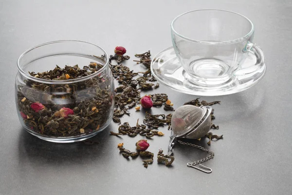 Spilled green tea with a rose and a strainer