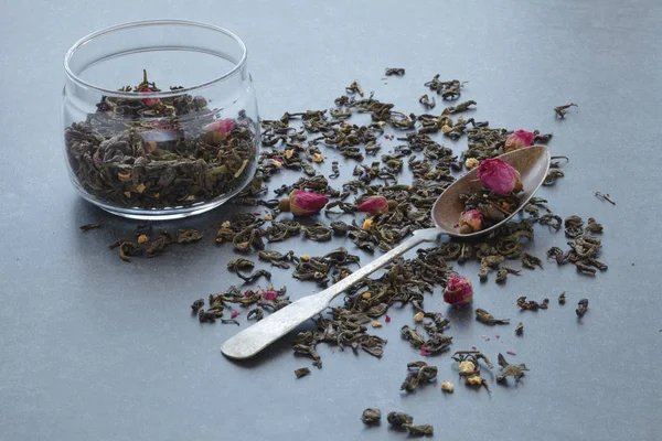 Пролитый зеленый чай с розой на каменном столе — стоковое фото