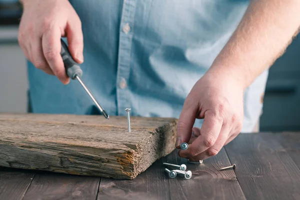 Mano dell'uomo utilizzando vite driver Assemblaggio assi di legno — Foto Stock