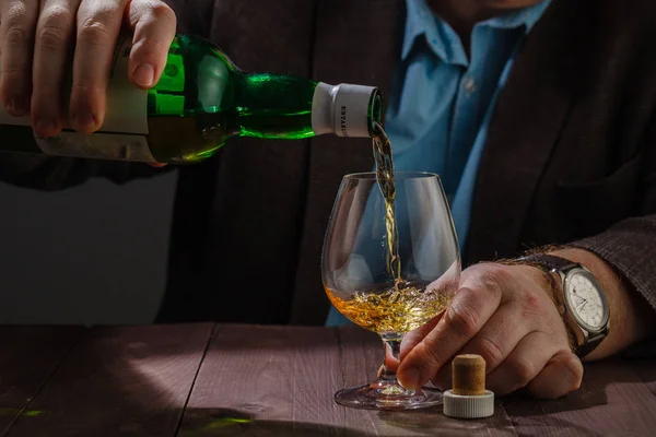 Człowiek sobie kurtkę trzymając szklankę whisky w barze licznik — Zdjęcie stockowe