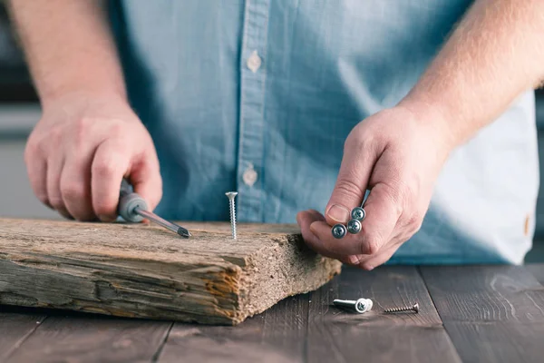 Avvitare una vite nel legno con un cacciavite — Foto Stock