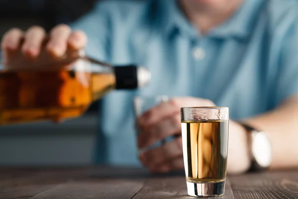 Homem está derramando tequila em vidro — Fotografia de Stock