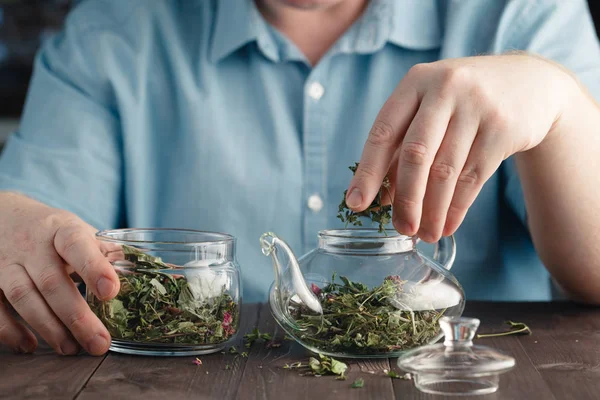 Человек готовит травяной чай в чайнике — стоковое фото
