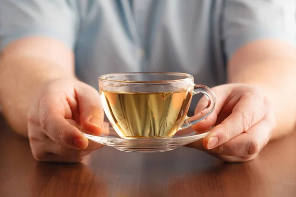 Чоловік тримає чашку в руці і пропонує чай — стокове фото