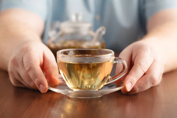 Mans manos y taza de vidrio de la medicina té de hierbas — Foto de Stock