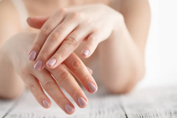 Manos de mujer aplicando crema hidratante a su piel — Foto de Stock