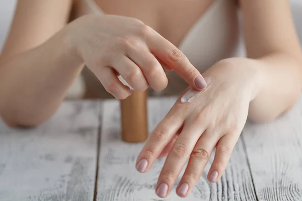 Hermosas manos femeninas con crema — Foto de Stock