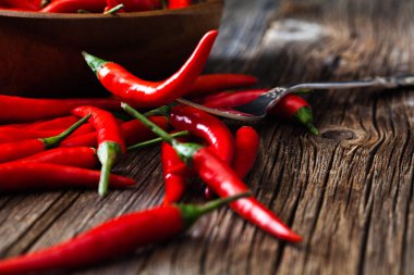 Ahşap backgrou üzerinde vintage gümüş çatal üzerinde kırmızı sıcak biber biber