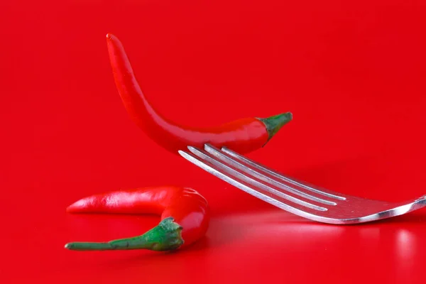 Cabai merah panas pada garpu perak vintage di atas latar belakang merah — Stok Foto