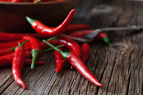 Red hot chili peppar på vintage silver gaffel över röd bakgrund — Stockfoto