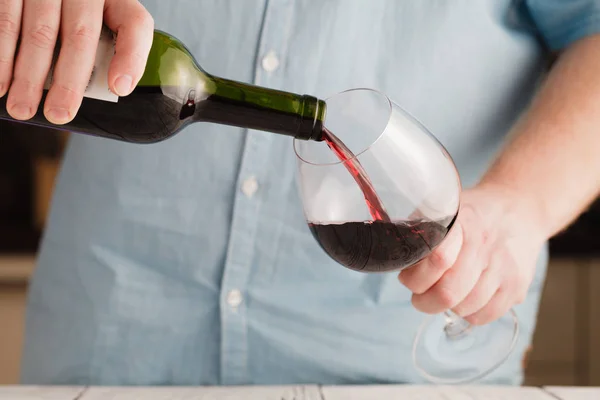 Rode wijn, gieten in een glas wijn. Ondiepe scherptediepte — Stockfoto