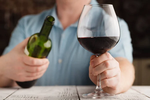 Man met een glas met rode wijn en fles — Stockfoto