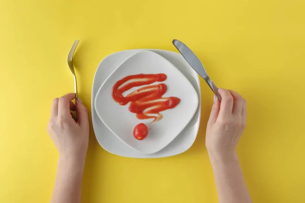 女人两个手拿勺子和叉子和黄色 b 上的白盘子里 — 图库照片