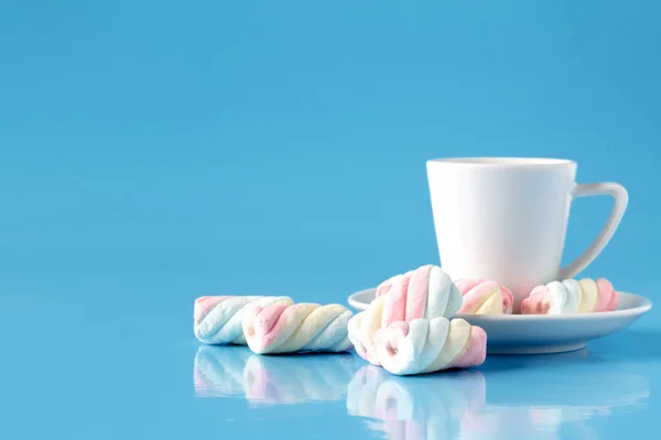 Tasse de café avec guimauve torsadée américaine sur fond bleu — Photo