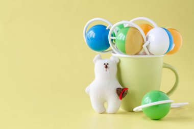 Bebek oyuncak ayı bebek ile sarı bir arka plan üzerinde çıngırak