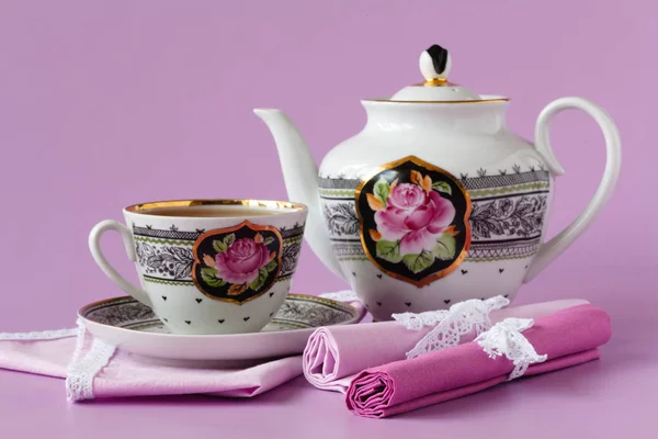 Porcelain tea pot and cup on pink background — Stock Photo, Image