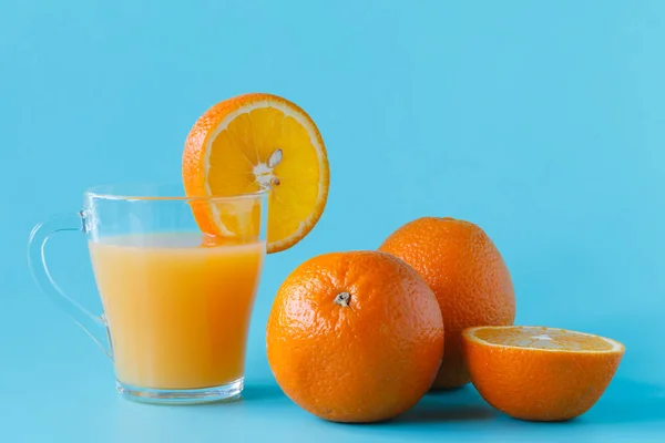 Glas Zitrussaft mit leuchtender Orange auf hellem Hintergrund — Stockfoto