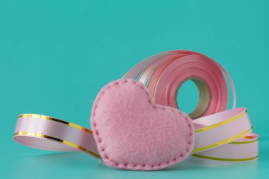 Pembe kurdele ve pembe bir arka plan üzerinde kalp.