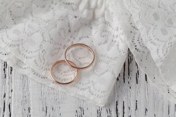 Los anillos en las flores en una tela blanca, detalles de la boda — Foto de Stock