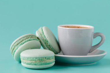 Fransız macarons ve Akuamarin arka plan üzerinde kahve fincanı