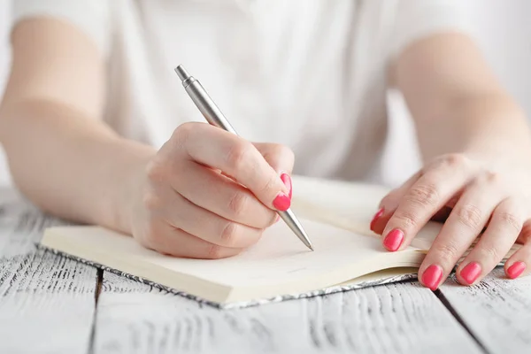 Ung kvinde skriver noter og planlægger sin tidsplan - Stock-foto