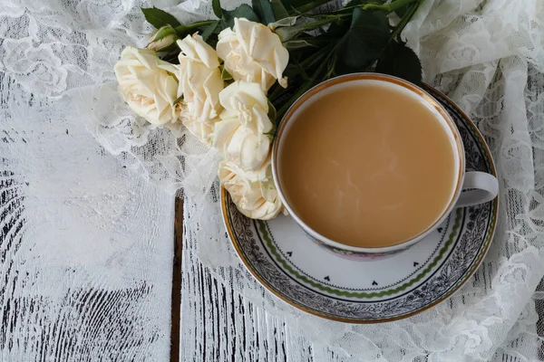 Ланцюг п'є гарячий чай на дерев'яній підлозі з красивими трояндами . — стокове фото