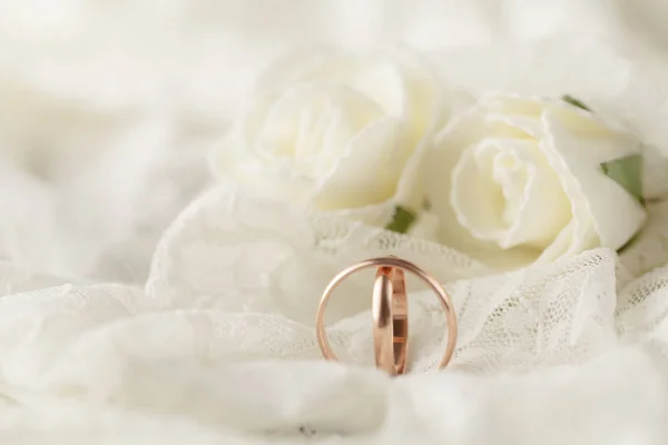 Par de anillos de boda dorados sobre tarjeta de invitación decorada con encaje — Foto de Stock