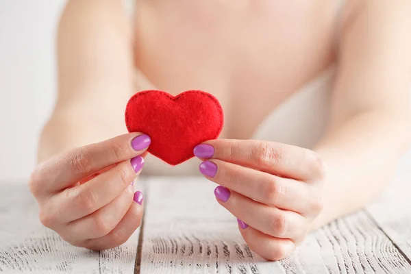 Heart in hands, female holds handmade sewn soft toy — Stock Photo, Image