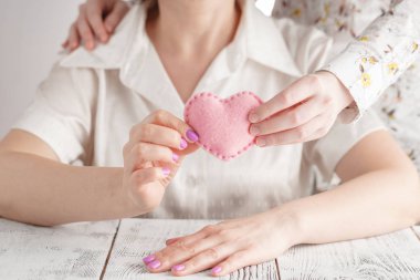 Kadın el kalbi olan çocuğun elini tutuyor. Annelik, sevecen, Aile, koruma, kavramını seviyorum