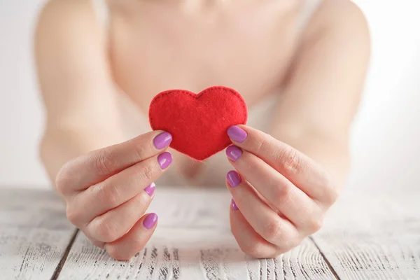 Giving love concept with hands holding a red heart. — Stock Photo, Image