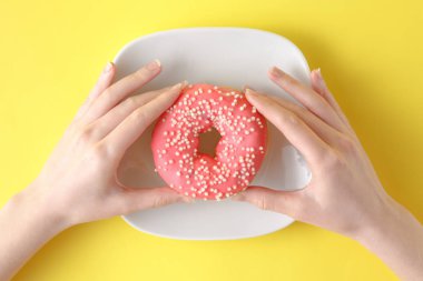 Lezzetli çörek renk arka plan üzerinde tutan kadın