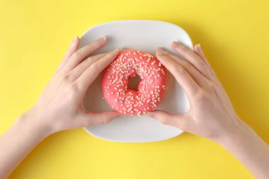 Lezzetli çörek renk arka plan üzerinde tutan kadın