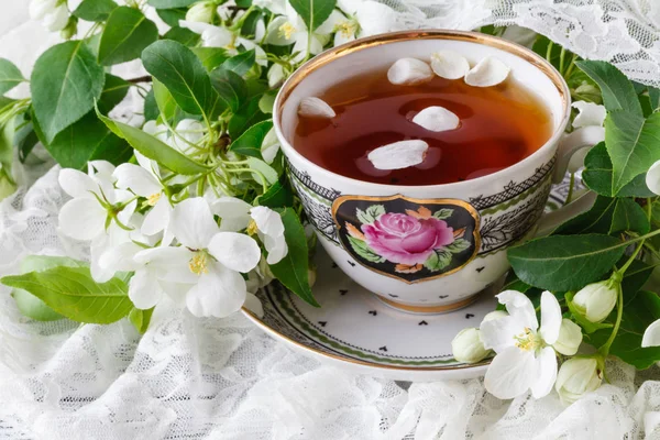 Kopp te på trä bord och apple blossom. Te tid koncept. Frukost te kopp serveras med blommor. — Stockfoto