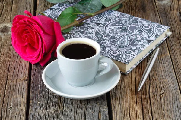 Livro com belas rosas e xícara de café na mesa de madeira de perto — Fotografia de Stock