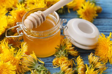 Arı bal bir cam kavanoz ve bir buket çiçekli karahindiba