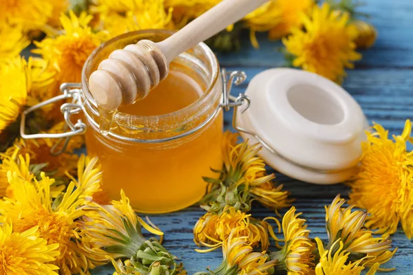 Arı bal bir cam kavanoz ve bir buket çiçekli karahindiba