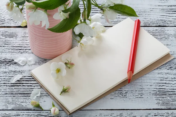 Nota, cartolina, scrivere fiori su un tavolo vintage in legno. Fiori rosa primaverili . — Foto Stock