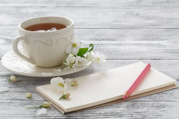 Natura morta con tazza di tè e ramo di fiori — Foto Stock
