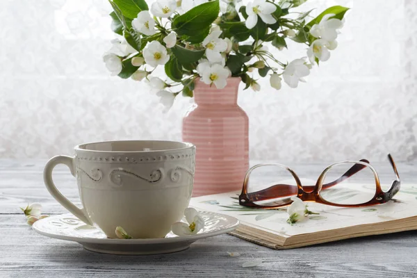 Stilleben med te kopp och blossom gren — Stockfoto