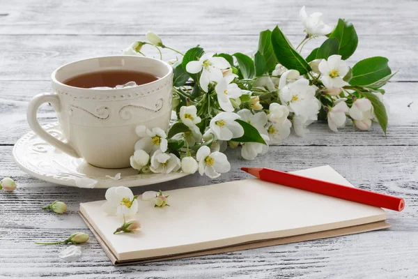 Tazza di tè verde e fiori di ciliegio giapponesi su sfondo blu — Foto Stock